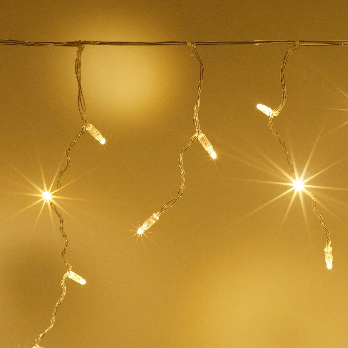 Nahaufnahme warmweiße LED Eiszapfen Lichterkette mit transparentem Kabel