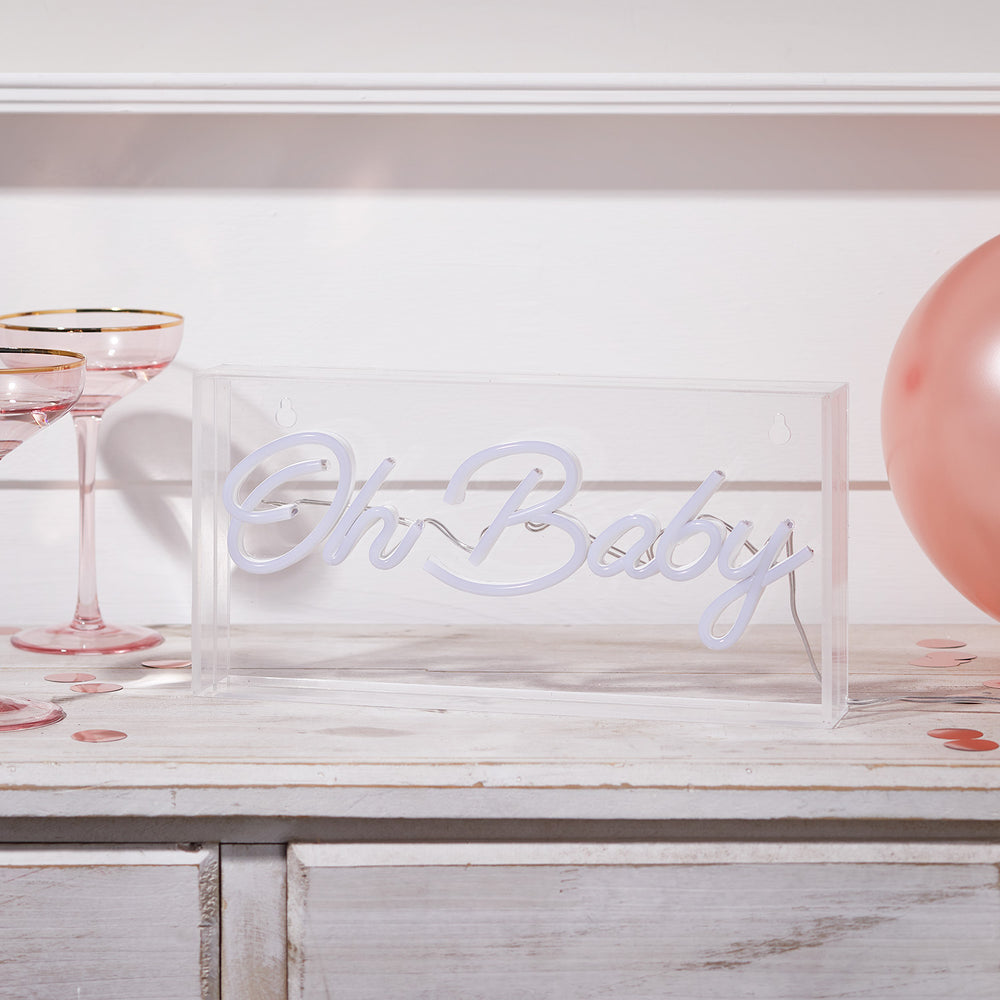 Neon Schriftzug Oh Baby in transparenter Acrylbox ohne Beleuchtung auf Holzfläche