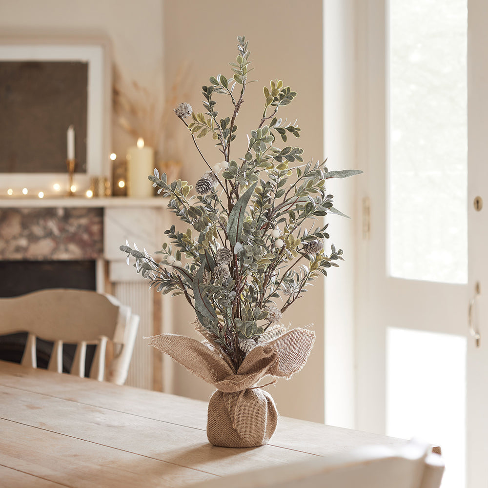 Kleiner 63cm hoher Weihnachtsbaum mit weißen Beeren und Jute umwickeltem Fuß auf Holztisch