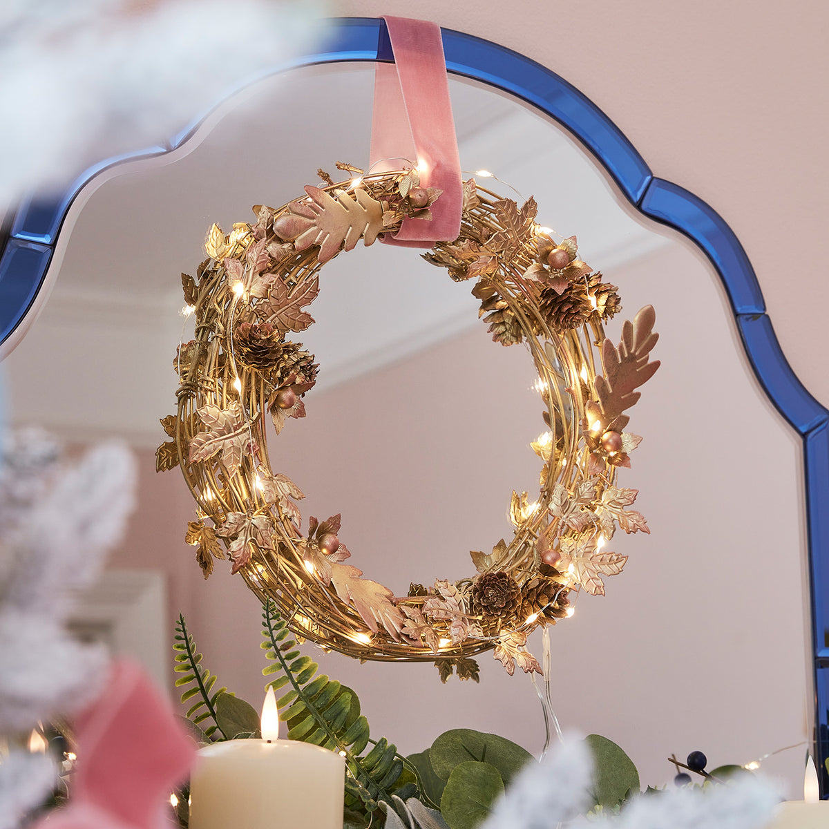 Goldener Weihnachtskranz mit Micro Lichterkette und rosa Samtschlaufe am Spiegel