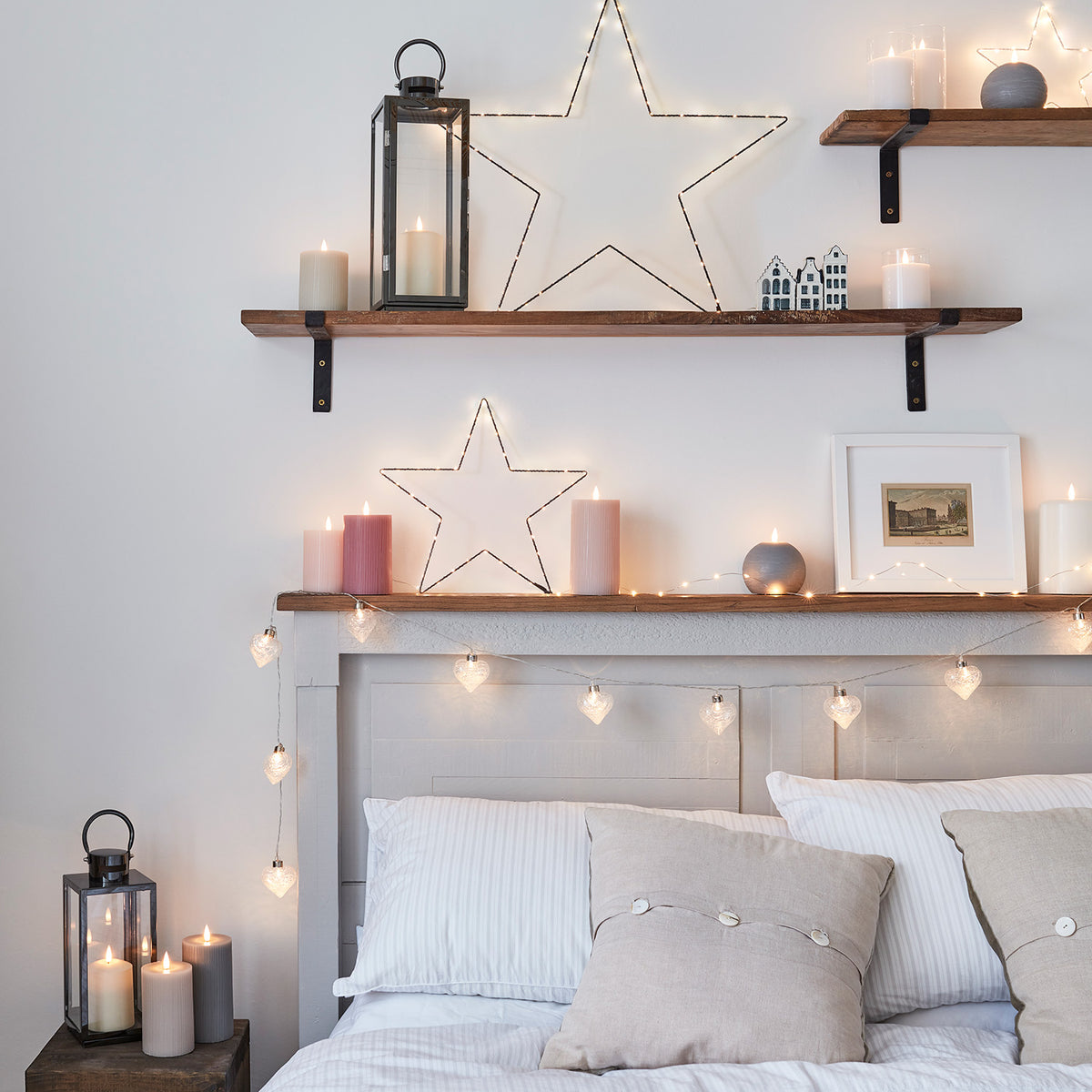 Schlafzimmer mit Holzregalen, Kerzen und einer dunkelgrauen Edelstahl Laterne mit TruGlow LED Kerze